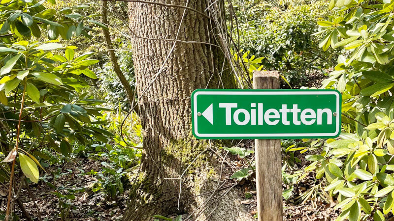 Hinweisschild Toiletten im Park